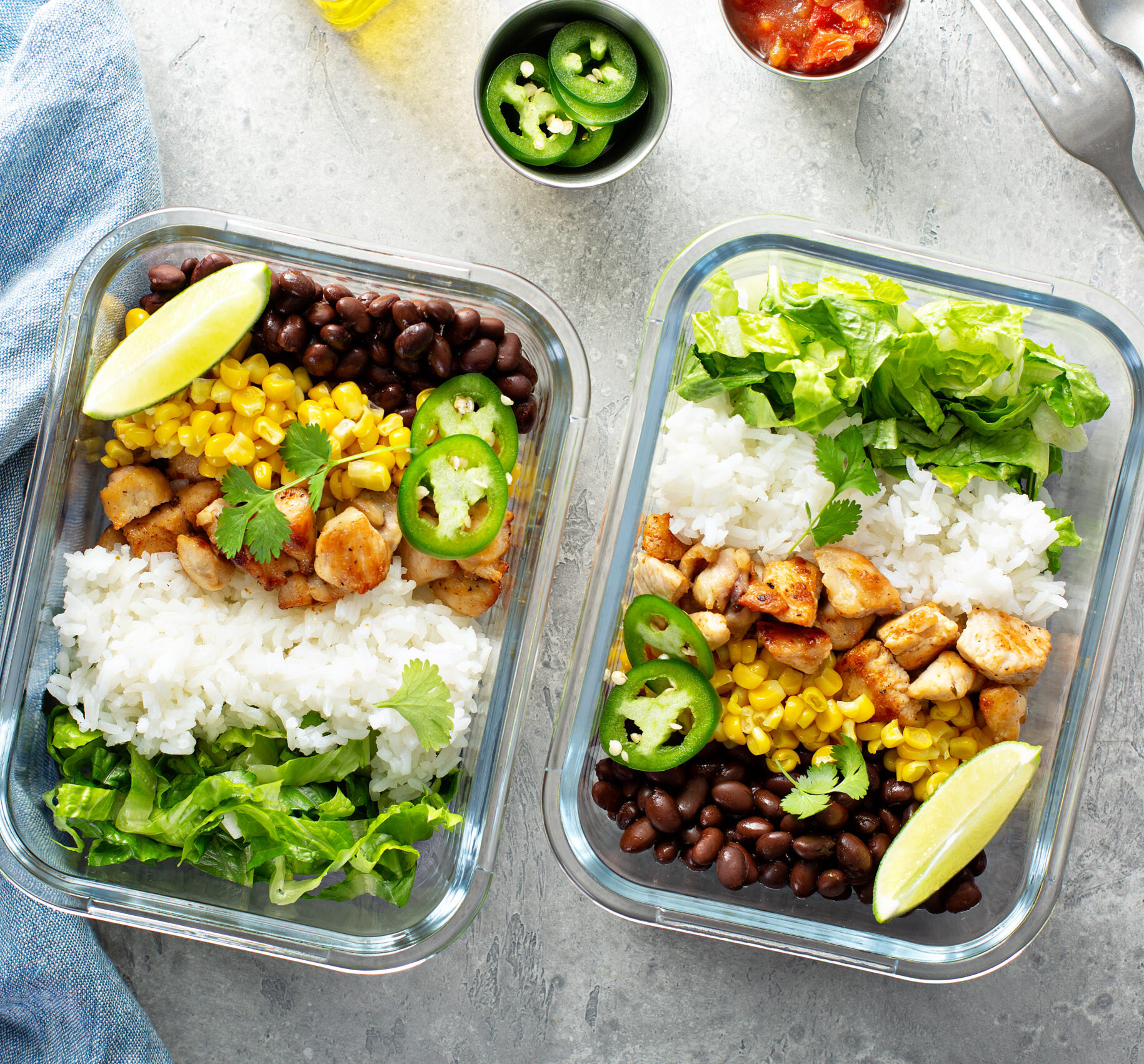 Healthy green mexican inspired meal prep with chicken, rice, beans, corn, salad